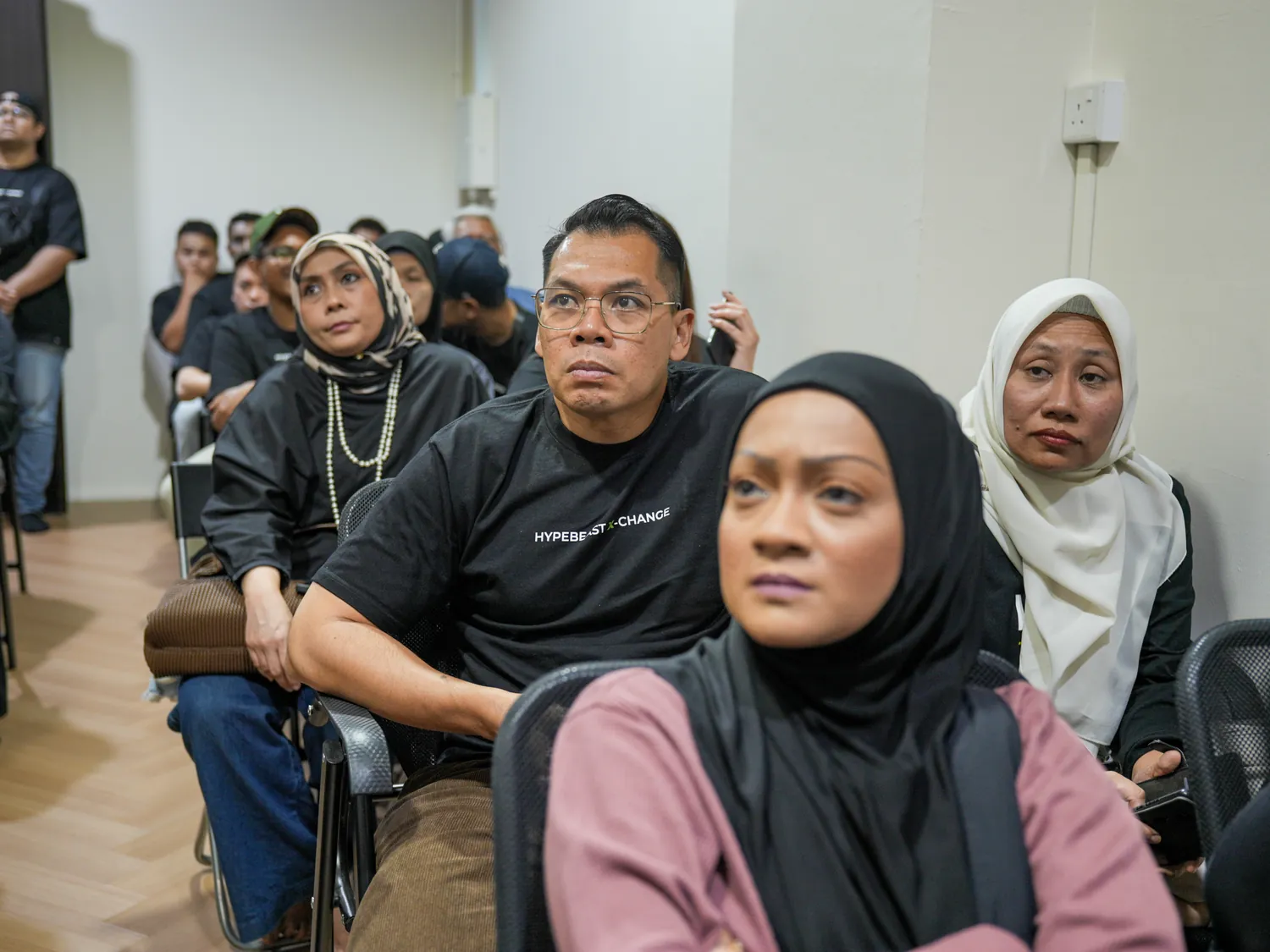 HBX members seated in rows, listening to another member speak